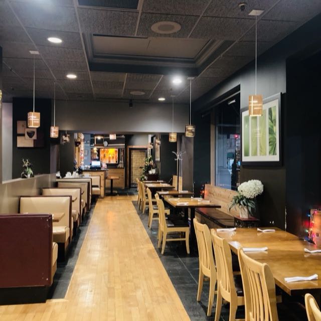 Amarit dining room with booths, wood tables and pendant lights