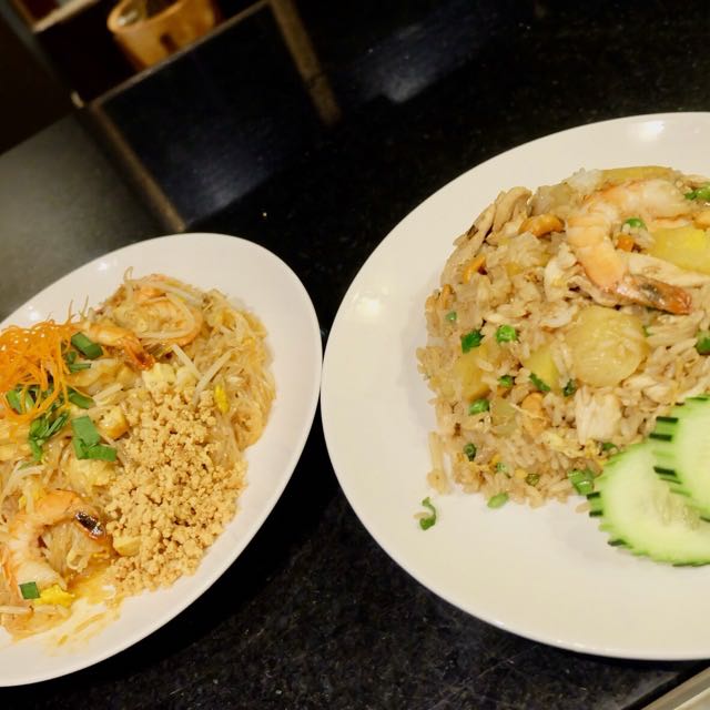 Shrimp pad thai and pineapple fried rice with cucumber slices