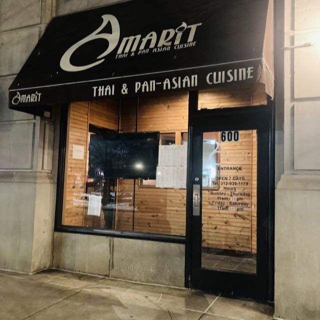 Amarit storefront at night with black awning reading Thai and Pan-Asian Cuisine