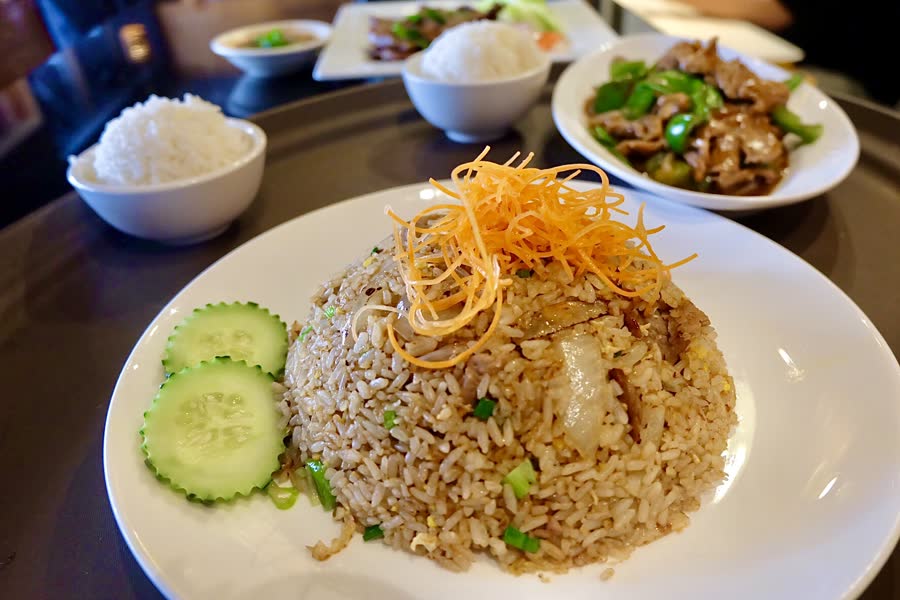Thai fried rice topped with shredded carrot, with cucumber slices