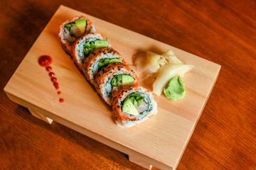 Viva Chicago roll on a wooden sushi board with ginger and wasabi